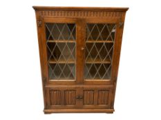 POLISHED OAK LINENFOLD BOOKCASE CUPBOARD, the upper section with twin leaded glass doors, 137cms