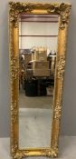DECORATIVE GILT FRAMED WALL MIRROR with bevelled glass, 170 x 58cms