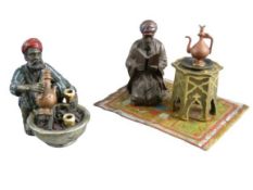 TWO MODERN BERGMAN STYLE CAST & PAINTED FIGURINES - one depicting a Northern African man squatting