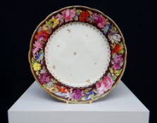 NANTGARW PORCELAIN PLATE circa 1815, of lobed form, the border painted with continuing garland of