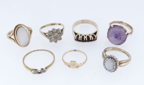 SEVEN YELLOW METAL RINGS comprising four 9ct gold rings including garnet and opal examples, together