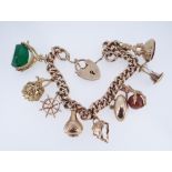 9CT GOLD CHARM BRACELET, the curb link chain with heart shaped padlock, having an assortment of nine