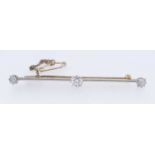 YELLOW METAL THREE STONE DIAMOND BAR BROOCH