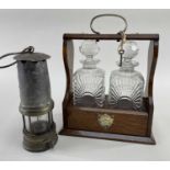 EDWARDIAN OAK TANTALUS & MINER'S LAMP, tantalus with two moulded glass spirit decanters (one with