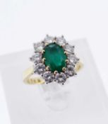 18CT GOLD EMERALD & DIAMOND CLUSTER RING, the central oval emerald (8 x 6mms), surrounded by ten