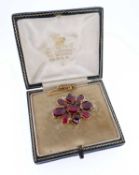 ANTIQUE GARNET SET FLOWER HEAD BROOCH, the flat cut stones housed in a yellow metal closed