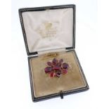 ANTIQUE GARNET SET FLOWER HEAD BROOCH, the flat cut stones housed in a yellow metal closed