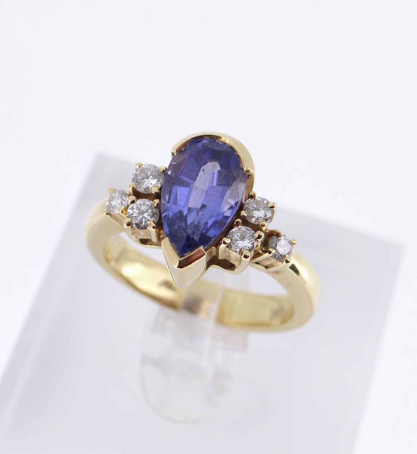 18K GOLD TANZANITE & DIAMOND RING, the central pear shaped tanzanite flanked by three diamonds