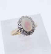 9CT GOLD OPAL & DIAMOND OVAL CLUSTER RING, the cabochon opal surrounded by a row of tiny diamonds,