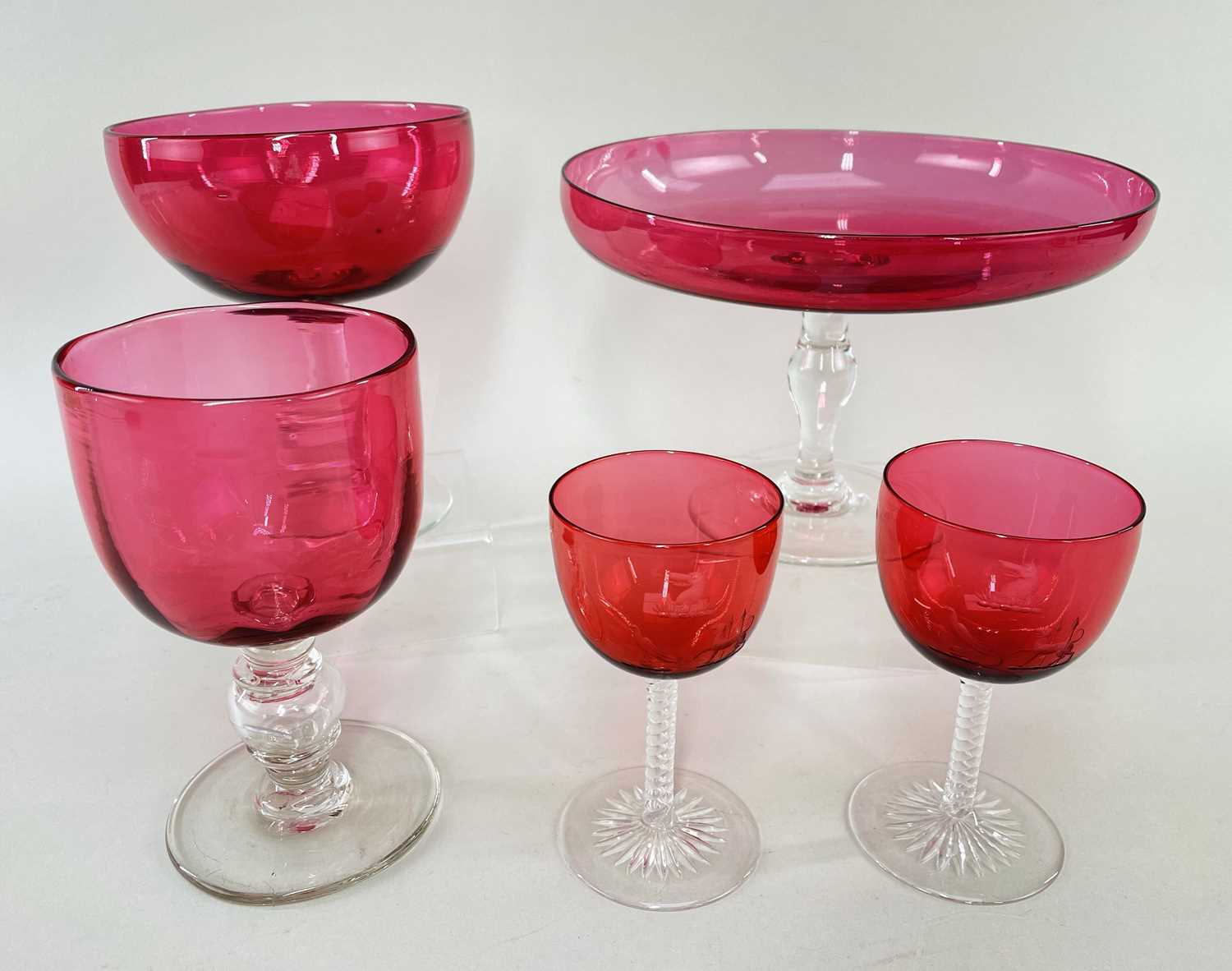 FIVE EDWARDIAN CRANBERRY GLASS STEMMED VESSELS, including pair wine goblets finely engraved with