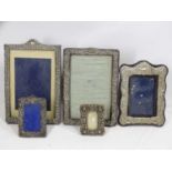 FIVE HALLMARKED SILVER EASEL BACK PHOTOGRAPH FRAMES to include three embossed and one pierced