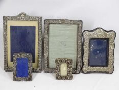 FIVE HALLMARKED SILVER EASEL BACK PHOTOGRAPH FRAMES to include three embossed and one pierced