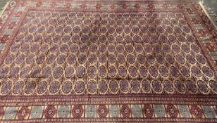 HANDMADE PERSIAN CARPET - ground red with a multi border and central diamond pattern, with