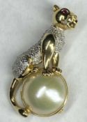 14CT GOLD PANTHER SURMOUNTING A HALF PEARL BROOCH - having 10 small diamonds to an illusion set body