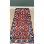 EASTERN RUG - central red ground with repeating traditional pattern and multi bordered edge, hand