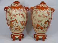 JAPANESE KUTANI LIDDED JARS, a pair, having front panels of scholars and applied elephant mask and