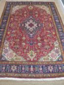 VINTAGE TABRIZ RUG, c. 1970, red, ivory and blue medallion on a red field with ivory spandrels, blue