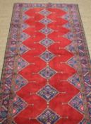 ARDEBIL RUNNER OR NARROW RUG, multiple lozenge medallion to a plain red field, blue border, brown