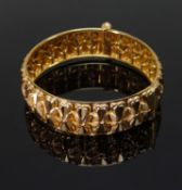 YELLOW GOLD LADIES BANGLE, of floral / bow repeating pattern with screw clasp, 35.0gms Provenance:
