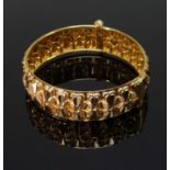 YELLOW GOLD LADIES BANGLE, of floral / bow repeating pattern with screw clasp, 35.0gms Provenance: