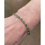 YELLOW METAL DIAMOND & EMERALD BRACELET, having twenty-six oval cut emeralds alternating with