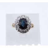 18CT GOLD SAPPHIRE & DIAMOND CLUSTER RING, the central sapphire (10 x 7mms) surrounded by ten