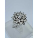 18CT WHITE GOLD DIAMOND CLUSTER RING, the central diamond (0.15cts approx.) surrounded by a