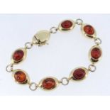 YELLOW GOLD SEVEN PANEL AMBER BRACELET, 20.5cms long, stamped '750', 19.9gms Provenance: private
