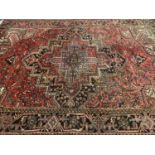 RED GROUND IRANIAN RUG with central multiple diamond pattern and label 'Iran Heriz Gerouan', 226 x