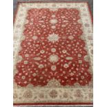 ANTIQUE EASTERN STYLE WOOLLEN RUG - red ground central section and a beige floral decorated
