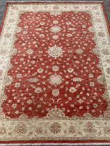 ANTIQUE EASTERN STYLE WOOLLEN RUG - red ground central section and a beige floral decorated