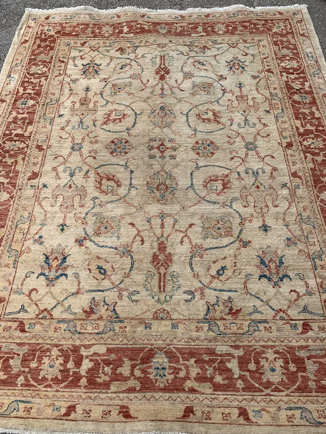 ANTIQUE EASTERN STYLE WOOLLEN RUG - cream ground with a red border and multi-patterned throughout,