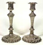 EPNS CANDLESTICKS, A PAIR - having profuse decoration in relief on circular petal form bases with