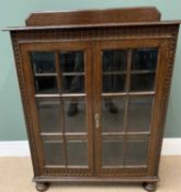ANTIQUE OAK BOOKCASE CUPBOARD with two sectional panelled glazed doors, railback top and on bun