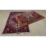 TWO SMALL ORIENTAL RUGS, both with central lozenge designed fields and multiple borders, one