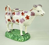 SWANSEA POTTERY COW CREAMER, c. 1830-40, iron red and pink lustre spots, 18cm long Comments: chip to