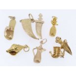 SIX VARIOUS YELLOW METAL CHARMS comprising yellow gold Jambiya dagger charm stamped '750', yellow