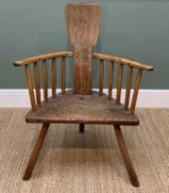WELSH OAK PRIMITIVE ARMCHAIR, with bowed arm rail above ten spindles, half circle seat on three