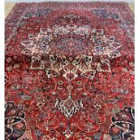 MAHAL RUG, centre with 16-point ivory star medallion on a madder scrolling vine field with pendants,