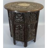 CARVED EASTERN HARDWOOD FOLDING TABLE - having profusely carved leaf and berry detail, the top