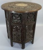 CARVED EASTERN HARDWOOD FOLDING TABLE - having profusely carved leaf and berry detail, the top