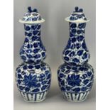 LATE 19th CENTURY CHINESE DOUBLE GOURD BLUE & WHITE VASES, with lids, a pair, 29cms H