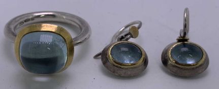 A 925 SILVER DRESS RING - with large cabochon aquamarine stone, having a yellow metal base band,