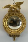 CONVEX BOBBLE MIRROR with eagle to the top, gilt framed, 57cms H, 35cms W