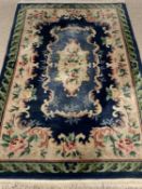 CHINESE WASHED WOOLLEN RUG, blue ground with tradition floral pattern centre and green leaf border