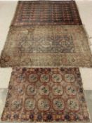 THREE WELL WORN ANTIQUE TYPE EASTERN STYLE RUGS, red and blue ground and multi-patterned with