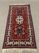 RED GROUND EASTERN STYLE RUG, multi-bordered with central traditional design, 193 x 98cms