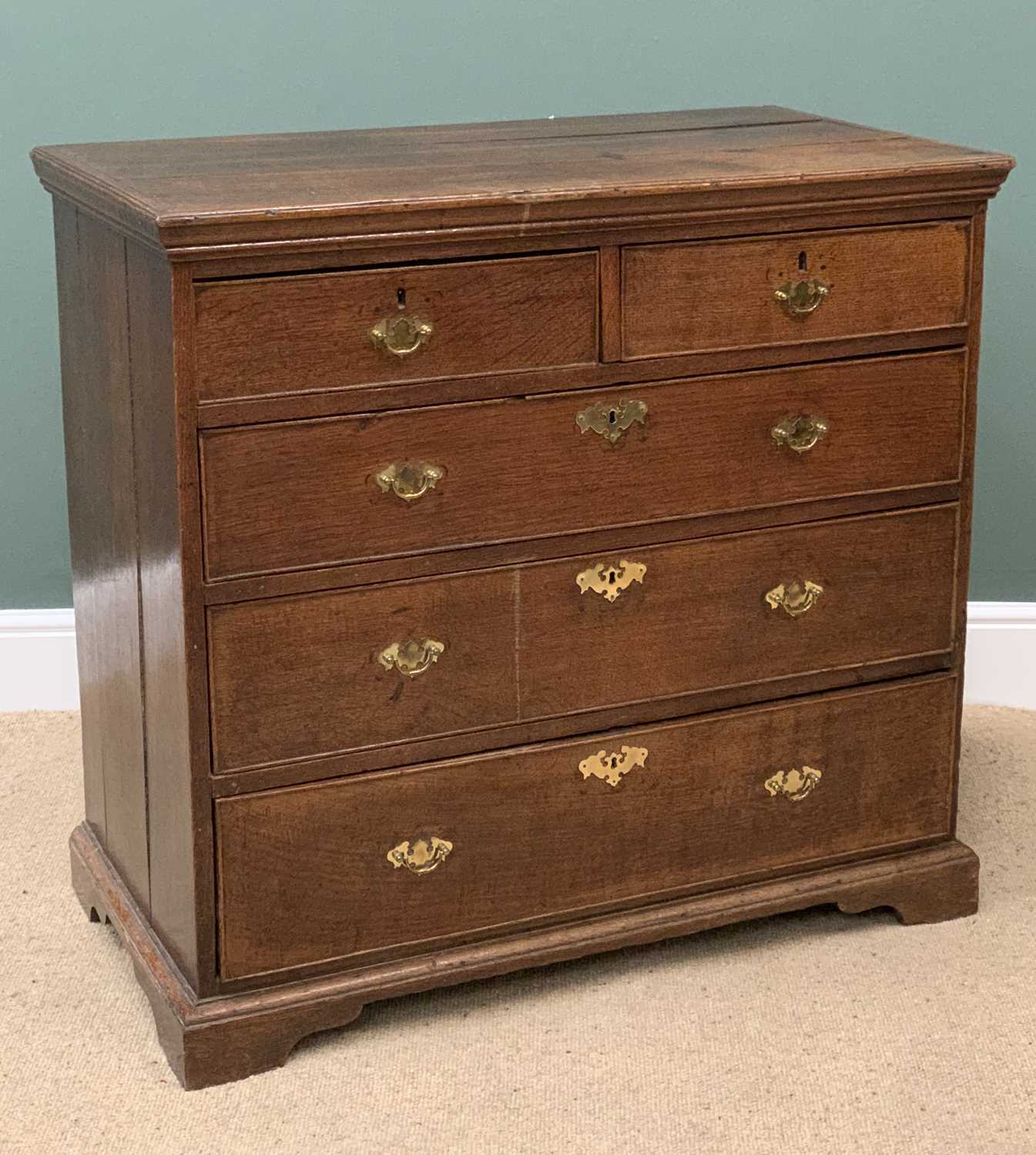 ANTIQUE OAK CHEST of two over three long drawers having brass swing handles and escutcheons, on
