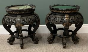CARVED EBONIZED & GILT HIGHLIGHTED CHINESE STANDS, baize covered circular tops with carved detail in