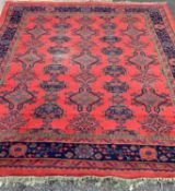 LARGE WOOLLEN TASSEL ENDED RUG, red ground with traditional pattern and wide bordered edging, 280